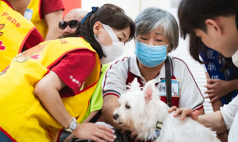 台積電慈善基金會志工與元培醫事科技大學寵物保健系、心輔犬培訓團隊合作,把狗醫生帶進新竹榮民之家與長輩同樂。圖片來源 / 台積電慈善基金會提供