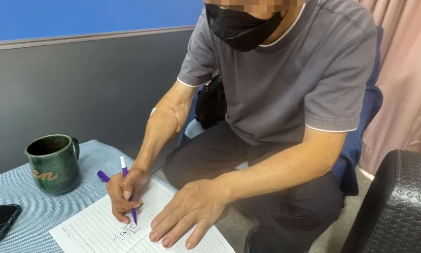 右手移植女性手臂的林先生,術後1年已能提筆寫字。圖片來源 / 林秀美攝