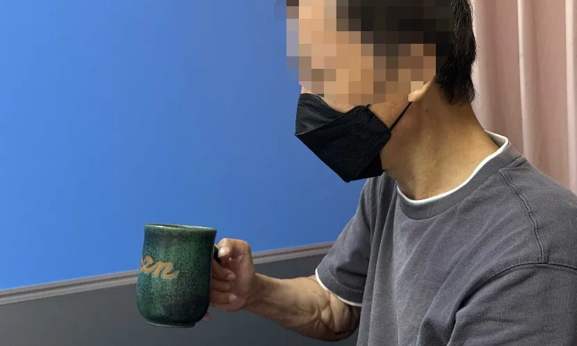 林先生右手移植的女性手臂已能舉杯,生活自理。圖片來源 / 林秀美攝