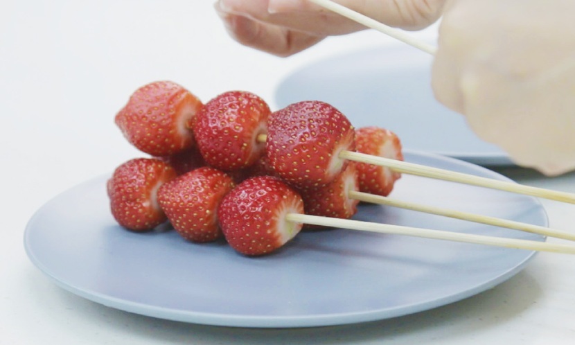 將草莓串成一串三顆，擺著備用